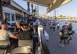 Los corredores avanzando por el paseo de Cabo de Palos, con las terrazas llenas, este sábado.