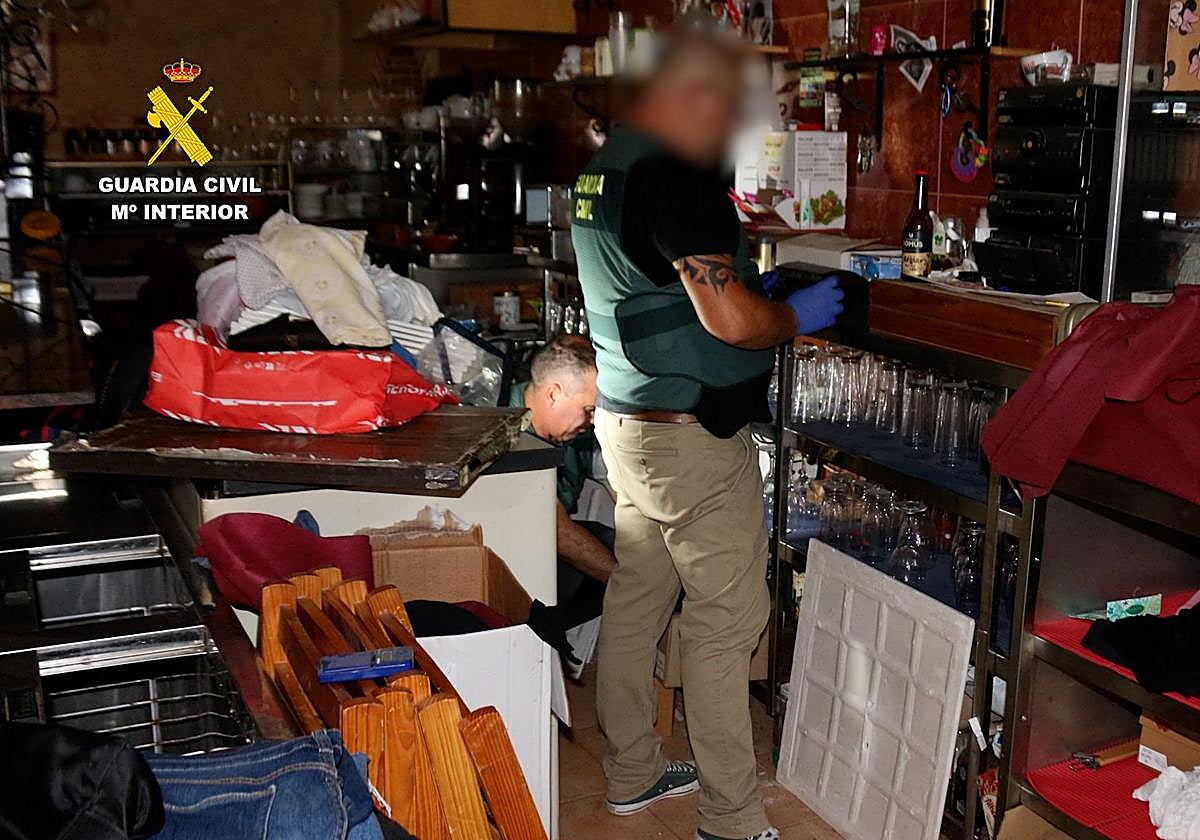 Dos agentes realizan inspecciones en el local donde se detuvo a los presuntos autores.