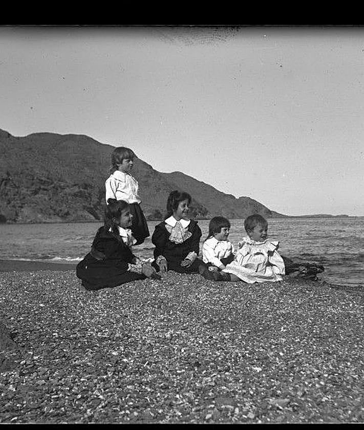 Imagen secundaria 2 - El Hornillo. Bote del buzo, fijando defensas en El Hornillo, según descripción del propio autor (c. 1902). | Isla del Fraile. Panorámica de la isla, con una boya en primer término (c. 1903). | Familia. Hijos de Gillman sentados junto a la orilla en la playa de El Hornillo (1899). 