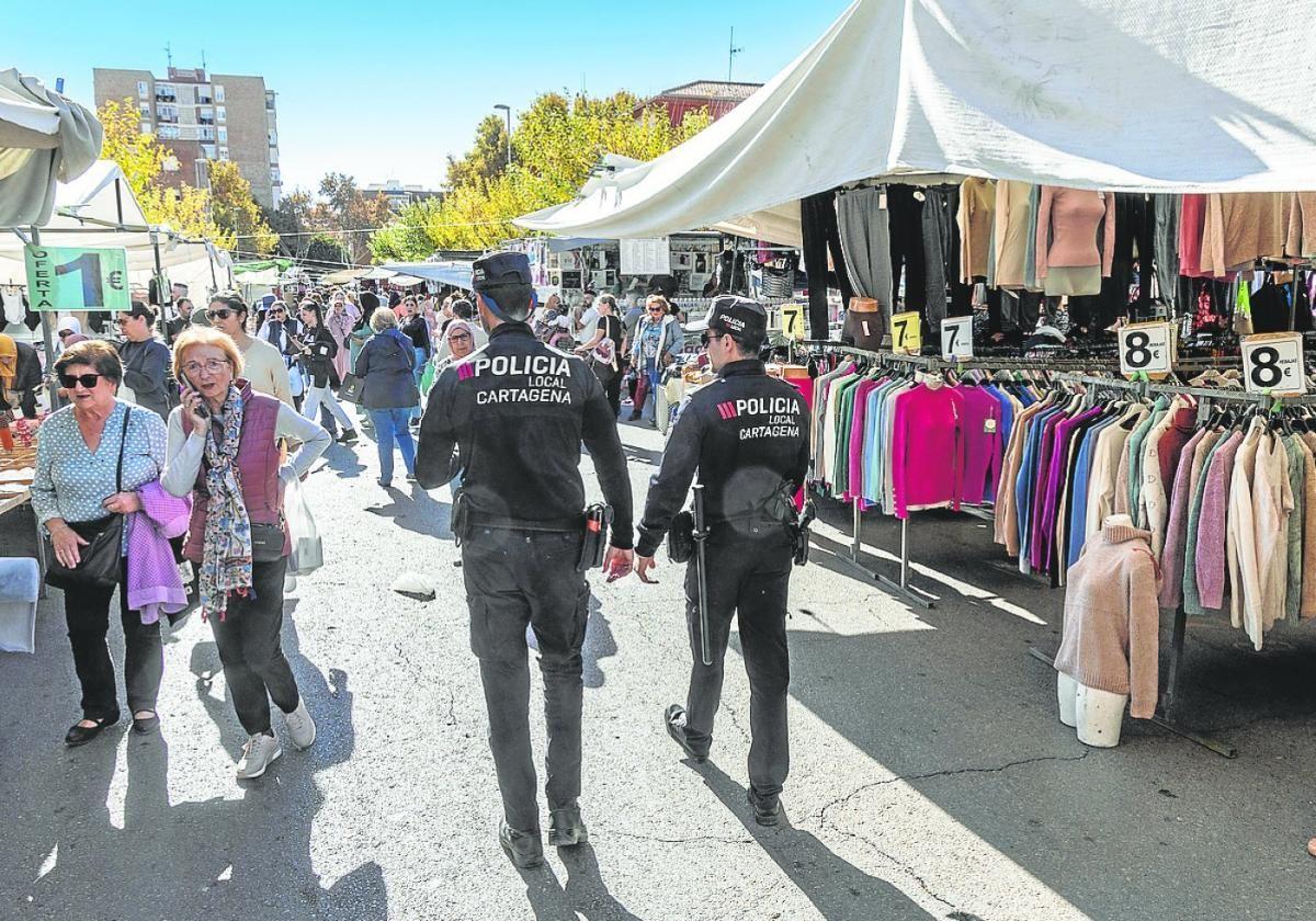 Dos policías locales patrullan por un mercadillo.
