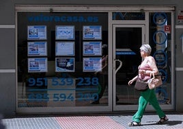 Una mujer frente a una inmobiliaria, en una foto de archivo.