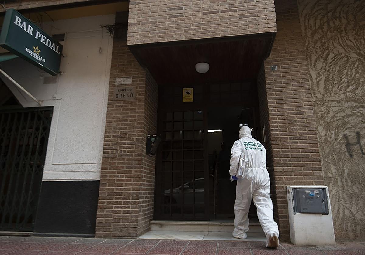 Un agente de la Guardia Civil entra al portal del piso de Cabezo de Torres donde se encontró el cadáver este domingo.