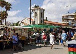 Vecinos y veraneantes de Los Urrutias recorren los puestos del mercadillo de la localidad de la ribera sur del Mar Menor.