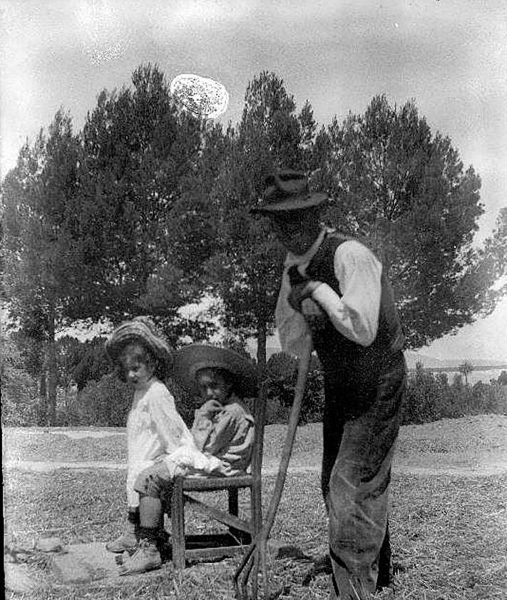 Imagen secundaria 2 - 1. Familias. Tres niños sobre un burro en la finca Casa de la Huerta. Dos de los niños son los hermanos Manuel y Alfonso Barnuevo Pérez de los Cobos (c. 1943). Colección Cristóbal Barnuevo Pérez de los Cobos. 2. Cieza. Niños sentados en el trillo y campesino apoyado en una horca (c. 1908-1910). Familia Moxó Ruano