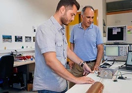 El autor de la tesis y su director observan la toma de medidas con la cavidad resonante a escala que han construido.