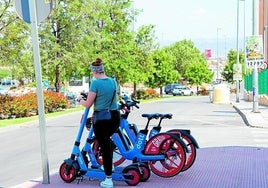 Una joven se dispone a coger un patinete eléctrico de alquiler en Lorca.