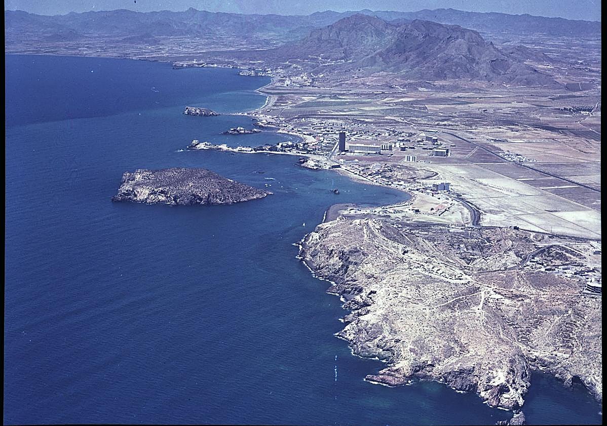 Imagen principal - Arriba, bahía mazarronera desde el este; al fondo, Bolnuevo y la Sierra de las Moreras (1971). | Abajo, vista aérea de la Ciudad del Aire, en Santiago de la Ribera, desde el sur (9-08-1969), y ciudad de Águilas y bahía de Levante desde el sureste (1971). 