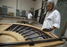 Mara Noguera, al fondo, y Montse Pasqual del Riquelme trabajan en la rejería de plomo de las puertas de entrada.
