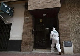 Un agente de la Guardia Civil entra al portal del piso de Cabezo de Torres donde se encontró el cadáver el domingo.