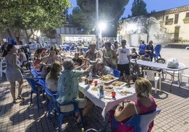 Los vecinos, de comida popular este pasado martes, en la plaza Pico Roldán y con el mural romano parcialmente calcinado, al fondo.