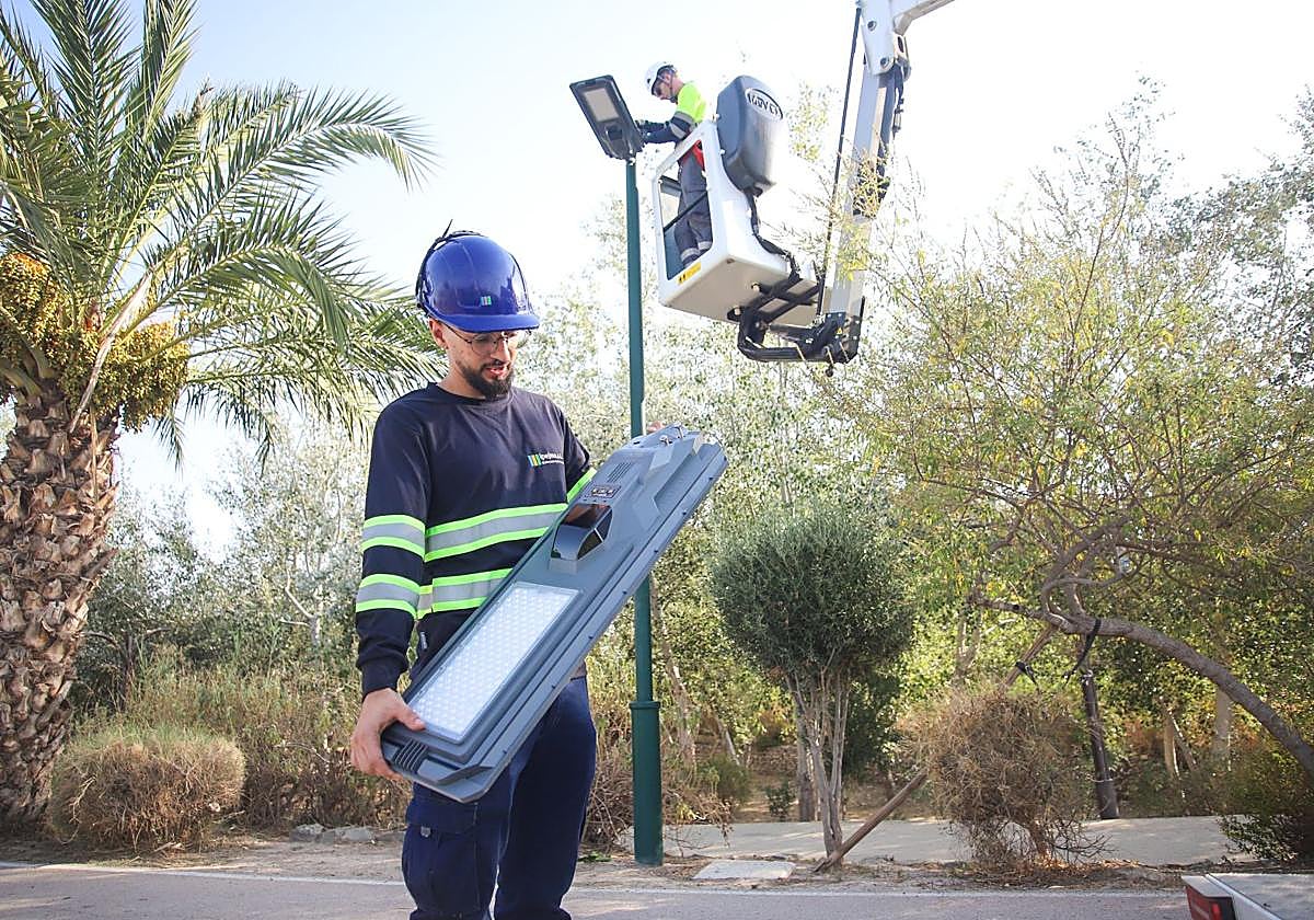 Dos ténicos con las nuevas farolas solares.
