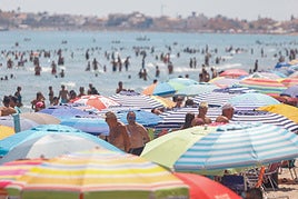 Un mar de sombrillas tomó este viernes la playa de Las Sirenas, en La Manga, mientras los bañistas se agolpaban en el agua para esquivar las altas temperaturas.