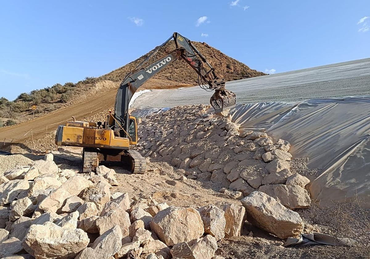 Una retroexcavadora trabaja en el sellado de la balsa minera San Cristóbal I, en Mazarrón, este verano.
