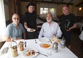 De izquierda a derecha, Vicente Rivas, Tomás Cegarra, jefe de cocina, Pedro Baños y Antonio Cegarra, jefe de sala, durante la comida con cuatro lámparas mineras sobre el mantel de la mesa y el típico porrón Belmonte.