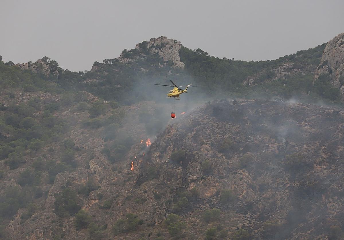 Un helicóptero lanza agua sobre las llamas en el incendio de Abarán.