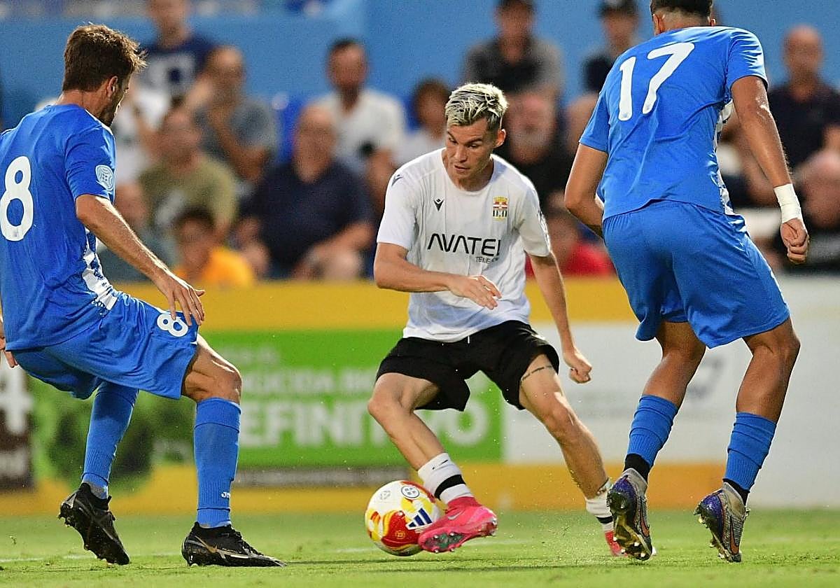 Luismi Redondo controla un balón ante la presión de dos jugadores del Águilas en un amistoso de esta pretemporada.