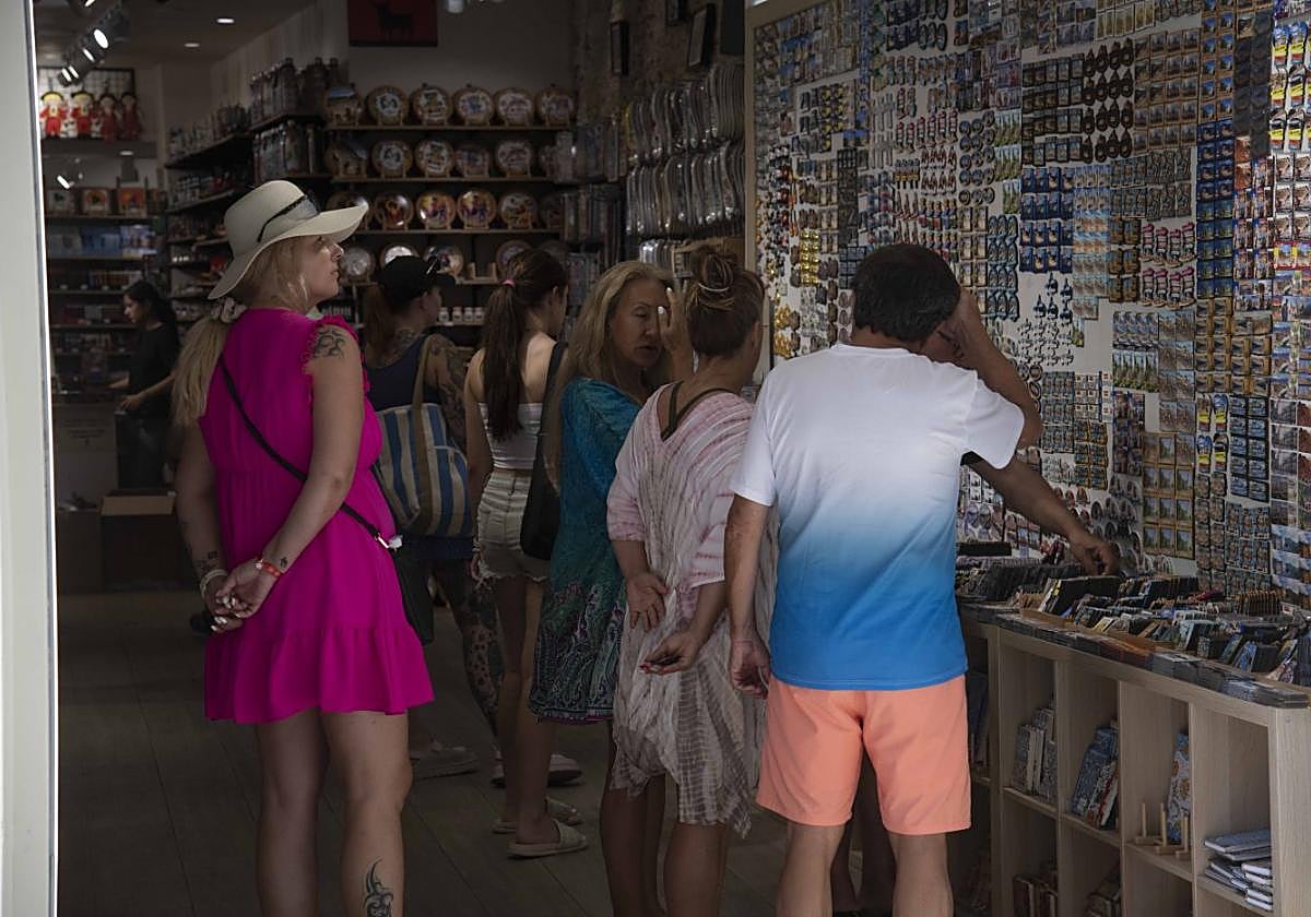 Varios turistas contemplan la oferta de artículos de recuerdo que ofrece una de las tiendas de souvenirs del centro de la ciudad, en una imagen de ayer.