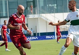Ekain, atacante del Real Murcia, conduce la pelota ante un defensa del Ilicitano.