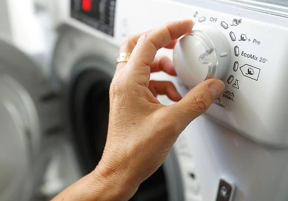 Imagen de archivo de una persona poniendo la lavadora.