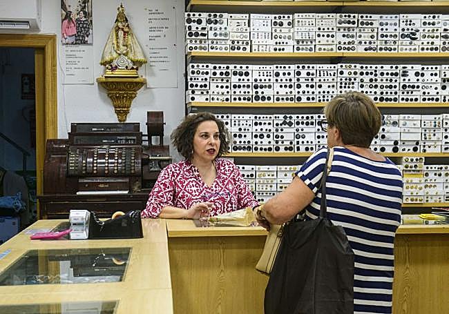 Fuensanta atiende a una clienta en la mercería, este mes de agosto.