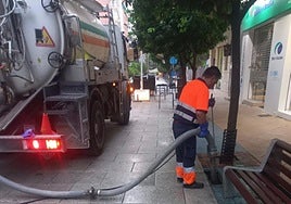 Un operario del servicio municipal limpia un imbornal. lv