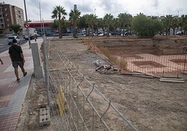Una pareja pasea frente al solar del parque de la Rosa donde una UTE acaba de reanudar las obras de construcción de una nueva escuela infantil.