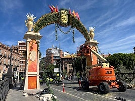 Trabajos de instalación de las decoraciones florales en el arco del Puente de los Peligros, este martes.