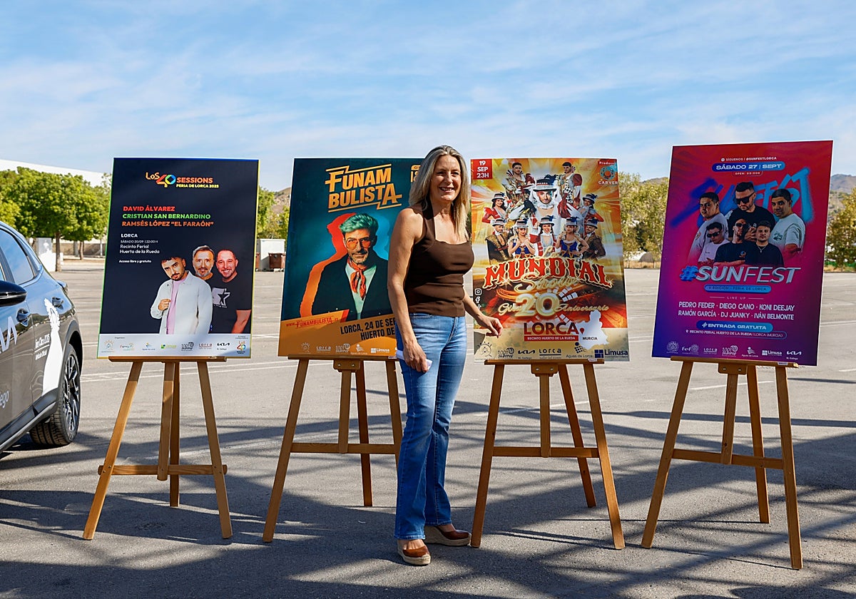 La concejala de Festejos ante los carteles de los artistas que actuarán con entrada gratuita en la feria.