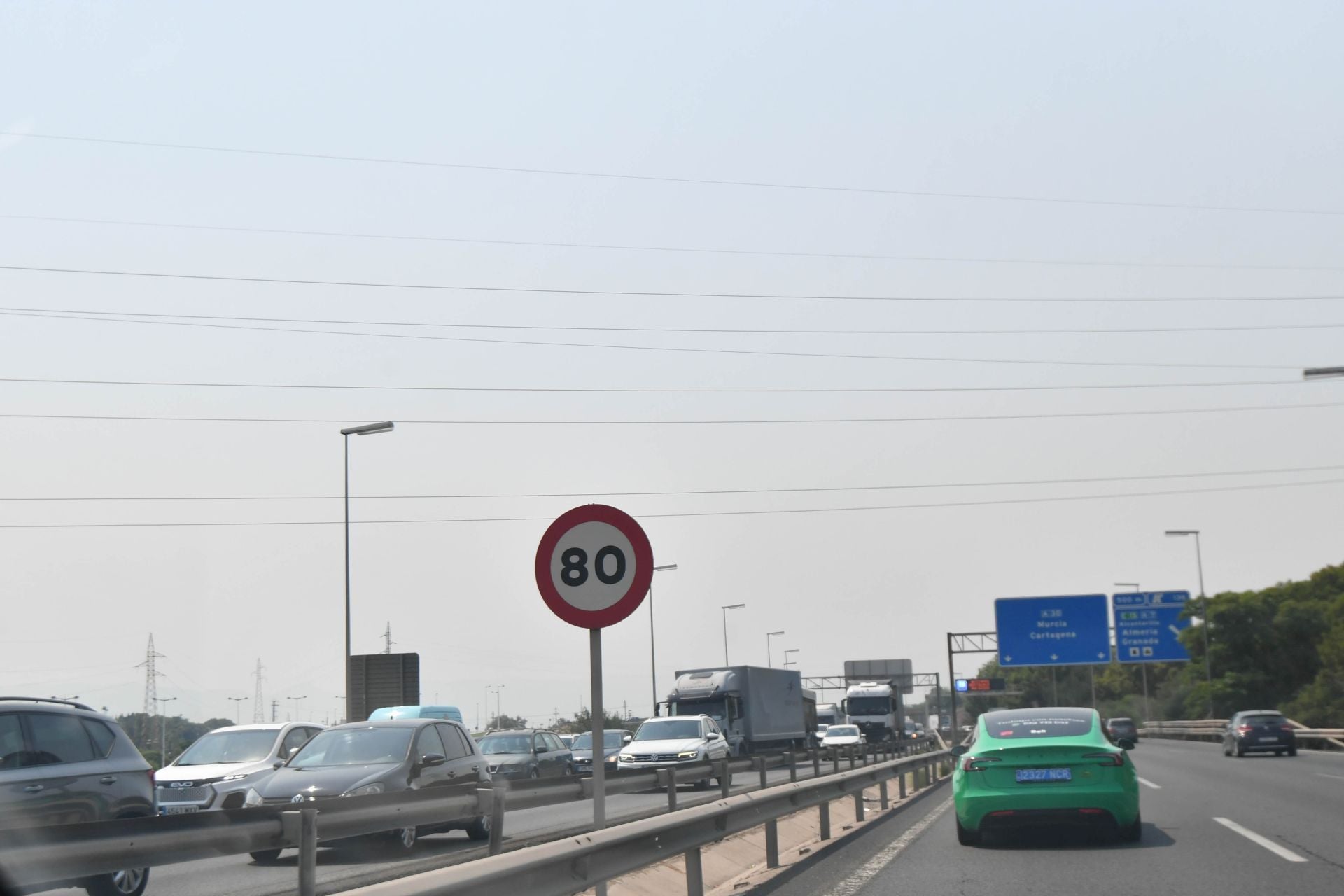 Coches circulando por la autovía a la altura de Murcia bajo un cielo afectado por la polución.