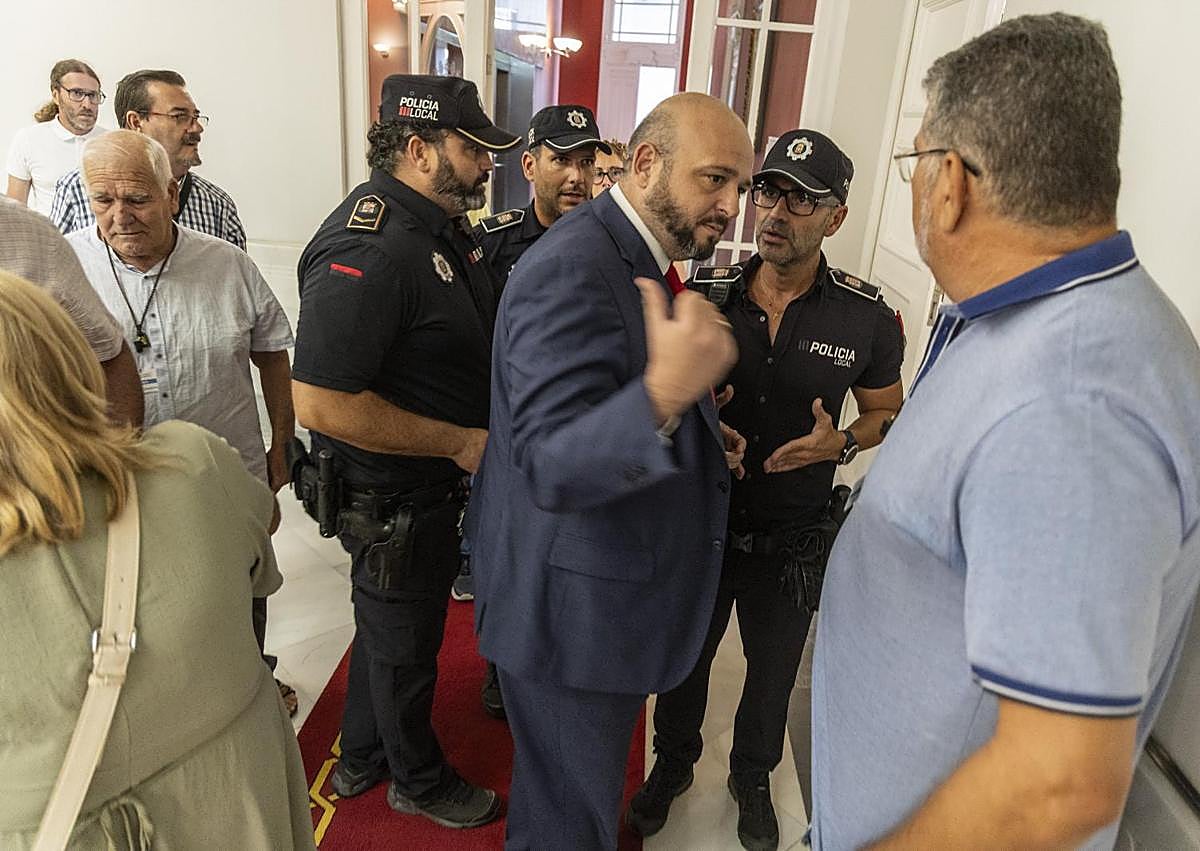Imagen secundaria 1 - Momentos de tensión vividos entre policías locales, representantes vecinales y concejal socialistas Manuel Torres fuera del salón de plenos.