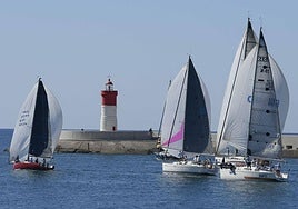 Los barcos tomando la salida en el puerto de Cartagena a su paso por el Faro de Navidad.