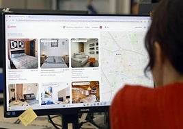 Una mujer repasa ofertas de alojamientos turísticos de Airbnb en Murcia.