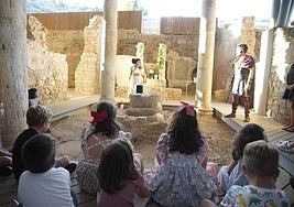 Festeros ataviado con sus trajes ante niños visitantes a uno de los centros.