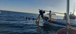 Un momento de la operación conjunta de buzos y pescadores para retirar la red.
