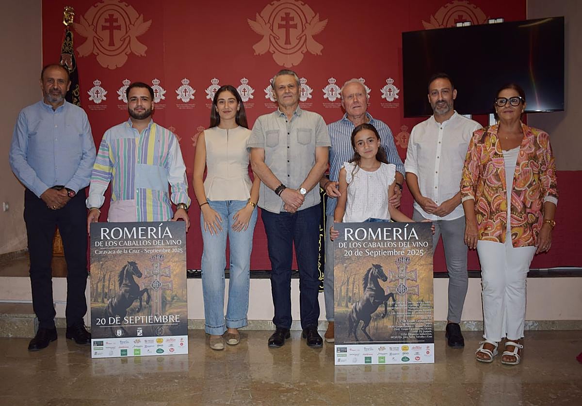 Representantes del Bando de los Caballos del Vino y autoridades, con el cartel anunciador de la romería