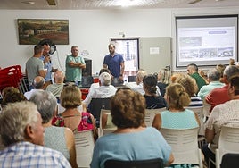 Los técnicos de la empresa escuchan al presidente vecinal, durante la reunión informativa.