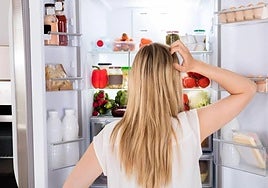 Imagen de archivo de una mujer mirando el interior de una nevera