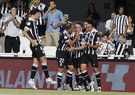 Los jugadores del Cartagena celebran uno de los goles ante el Atlético Madrileño con varios aficionados detrás.