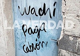 Pintada en la puerta de la vivienda incendiada en mayo de 2024, donde murieron tres personas.