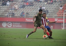 Joao Pedro Palmberg, futbolista del Real Murcia, intenta jugar bajo la oposición de Juanma, del Algeciras.