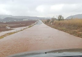 La carretera de Los Nietos que conecta con la autovía, repleta de agua.