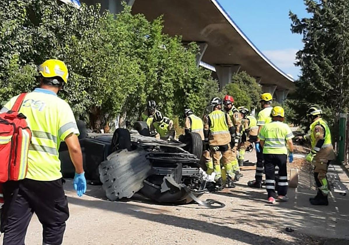 Efectivos de emergencias trabajan bajo el viaducto, donde cayó el coche.