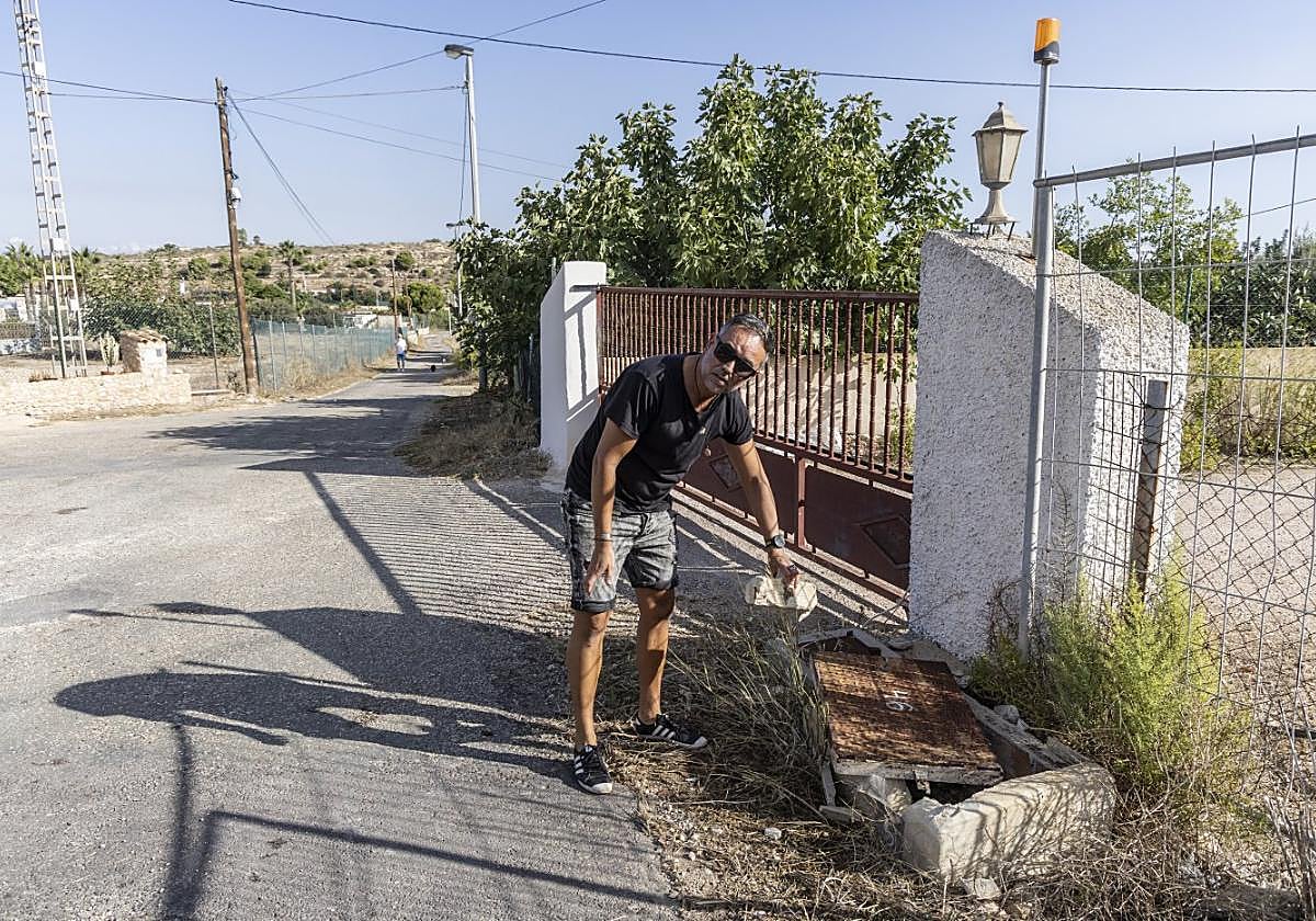 Fernando Martínez Saura muestra uno de los contadores rotos por un camión de basura.