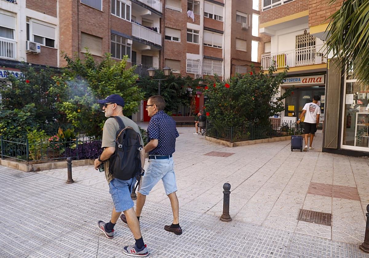 Dos personas caminan junto a la plaza privada de la calle Tirso de Molina.