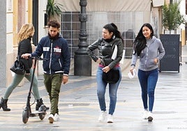Un joven camina con un patinete en la calle Corredera, en una imagen de archivo.