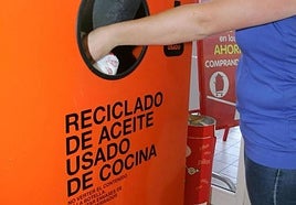 Una mujer deposita su aceite usado en uno de los contenedores de recogida de la ciudad.