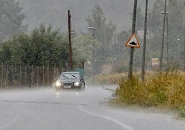 Un vehículo circula bajo la lluvia, en el este del municipio de Murcia.