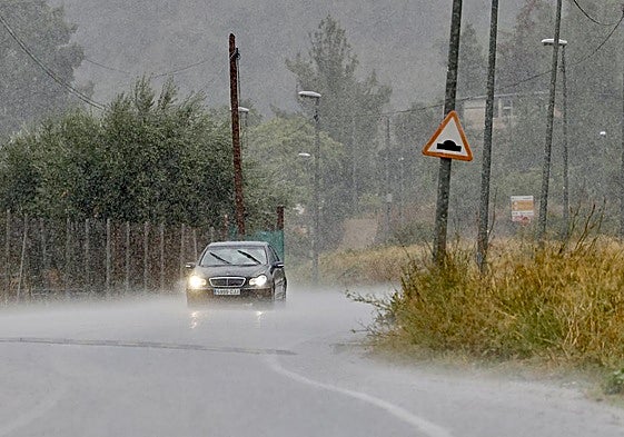 Un vehículo circula bajo la lluvia, en el este del municipio de Murcia.