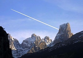 La estela que deja un avión reactor que sobrevuela los Picos de Europa parece salir del mismo Naranjo de Bulnes.