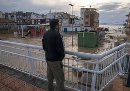 Un joven mira el paseo marítimo de Los Alcázares anegado.